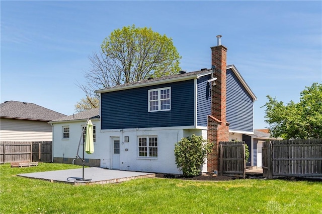 back of house featuring a chimney, brick siding, fence, a yard, and a patio