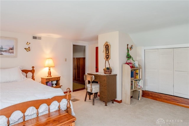 bedroom featuring visible vents, light carpet, and a closet