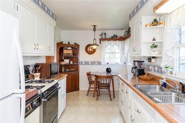 kitchen with a sink, open shelves, white appliances, and light countertops