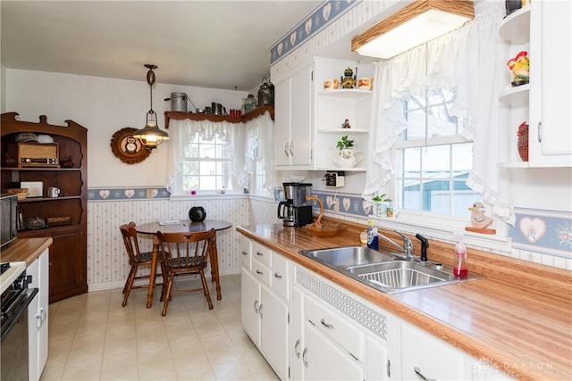 kitchen featuring a sink, open shelves, electric range, and wallpapered walls