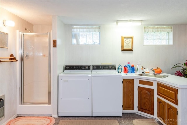 clothes washing area featuring laundry area, a sink, and independent washer and dryer