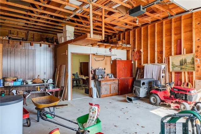 garage with a garage door opener and wood walls