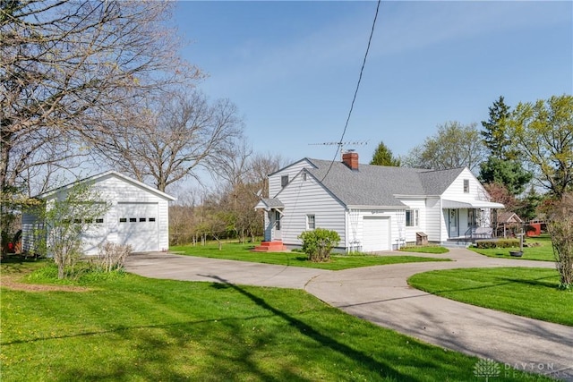 view of property exterior with a shingled roof, a detached garage, an outbuilding, a chimney, and a lawn