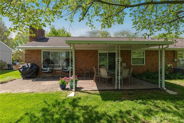 4600 Wing View Ln, Kettering, OH 45429 - back of property featuring brick siding, a chimney, a patio area, and a lawn
