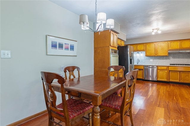 4600 Wing View Ln, Kettering, OH 45429 - dining area featuring a chandelier, wood finished floors, and baseboards