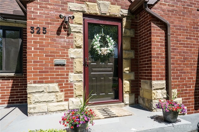 doorway to property with brick siding