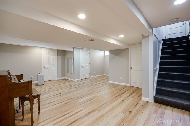 finished basement with visible vents, stairs, baseboards, light wood-type flooring, and recessed lighting