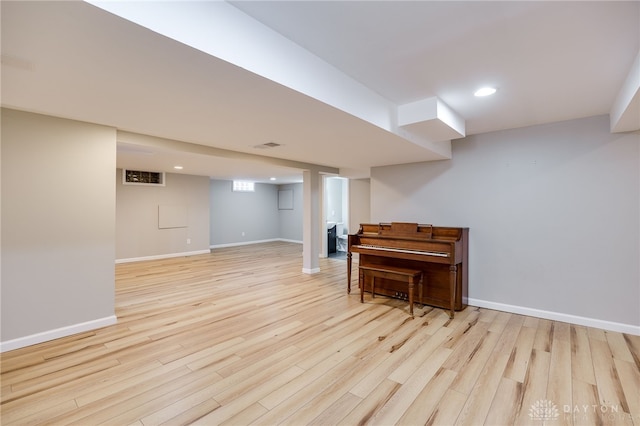 finished basement with recessed lighting, baseboards, and light wood-type flooring