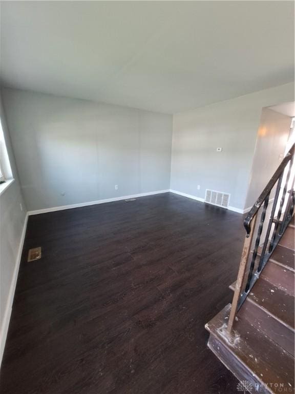 interior space with stairs, baseboards, visible vents, and wood finished floors