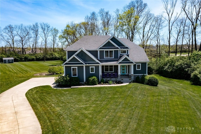 craftsman-style house featuring covered porch, concrete driveway, and a front lawn