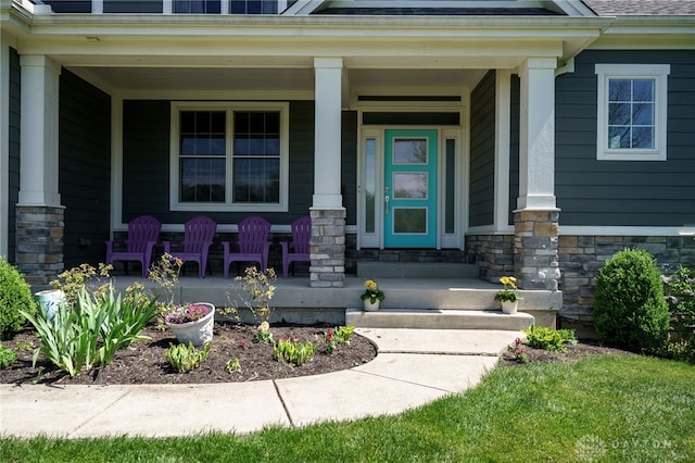 doorway to property featuring a porch and stone siding