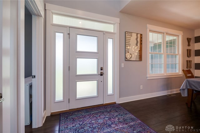 foyer featuring baseboards and dark wood finished floors
