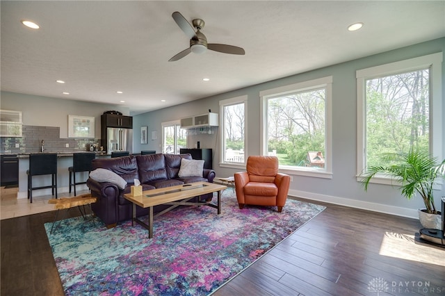 living area with recessed lighting, a ceiling fan, baseboards, and wood finished floors