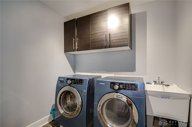 laundry room featuring a sink, baseboards, independent washer and dryer, and cabinet space