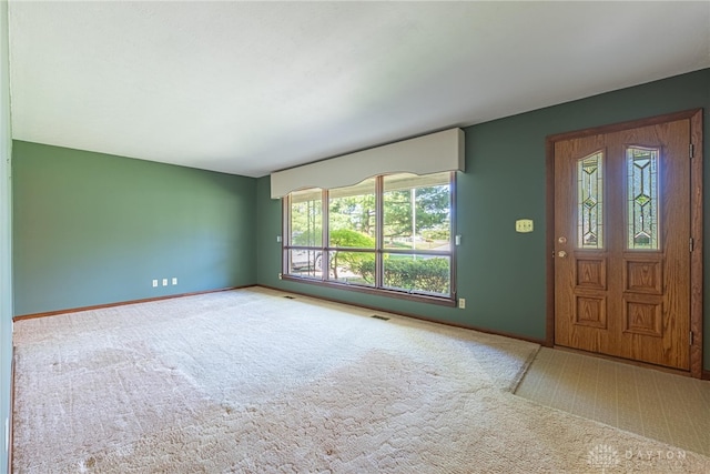 carpeted entryway with visible vents and baseboards