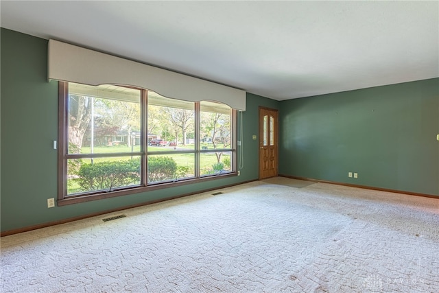 carpeted empty room with visible vents and baseboards