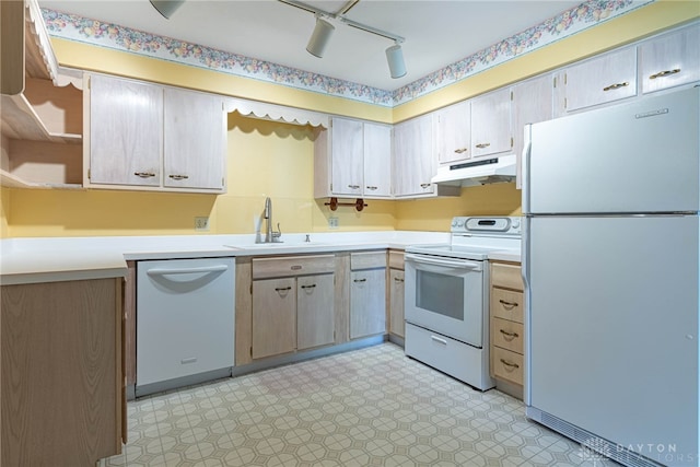 kitchen with white appliances, light floors, light countertops, under cabinet range hood, and a sink