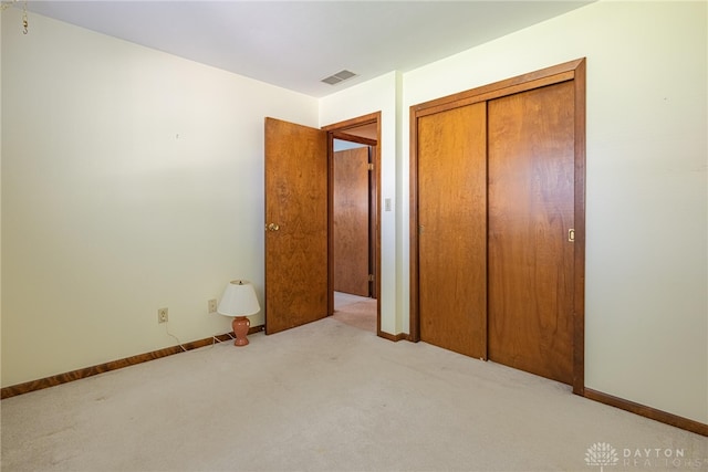 unfurnished bedroom featuring carpet flooring, baseboards, visible vents, and a closet