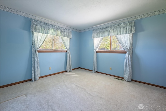 unfurnished room featuring baseboards, carpet, and visible vents