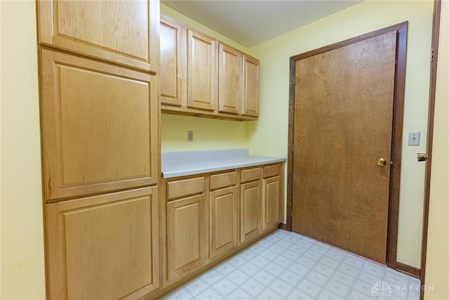 clothes washing area featuring light floors