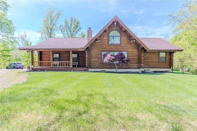 view of front of home with a front lawn, a chimney, and log siding