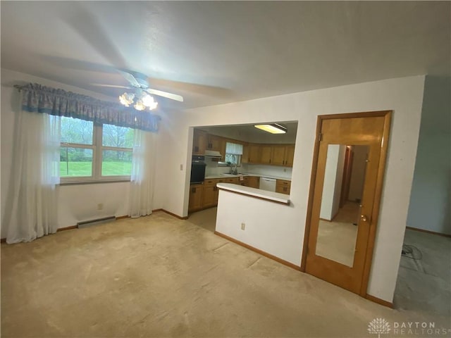 unfurnished living room with baseboards, light carpet, and a baseboard heating unit