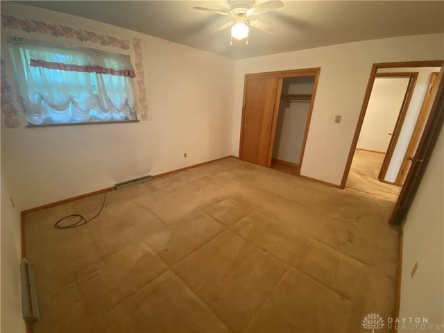 unfurnished bedroom with ceiling fan, light colored carpet, baseboards, visible vents, and a closet