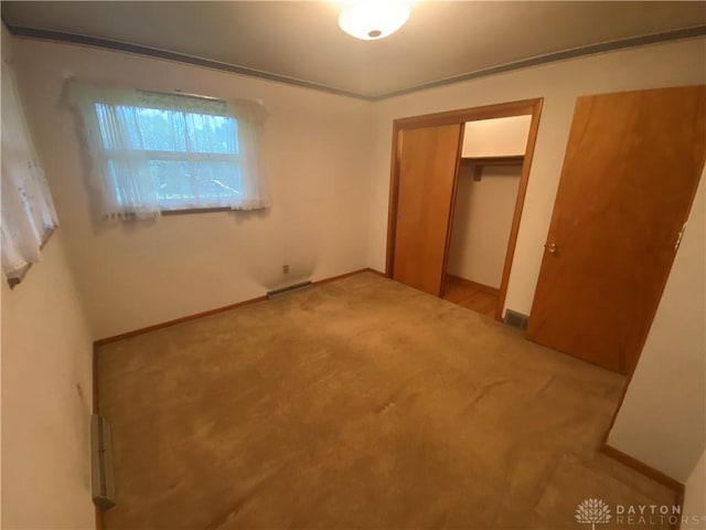 unfurnished bedroom with visible vents, carpet, baseboards, and a closet