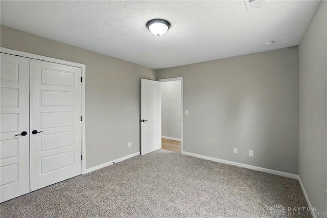 2067 Pine Forest Dr, Miamisburg, OH 45342 - unfurnished bedroom featuring carpet floors, baseboards, a closet, and a textured ceiling