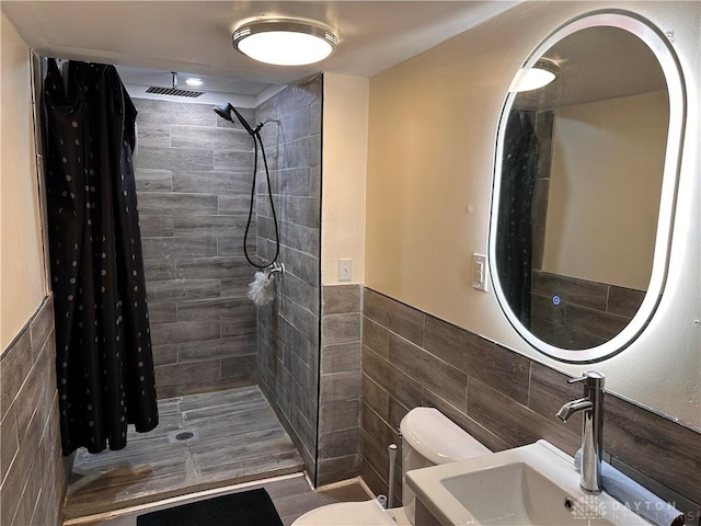 1566 Cora St, Springfield, OH 45503 - bathroom featuring tile walls, a tile shower, and wainscoting