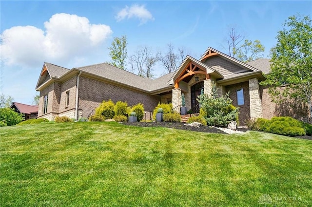 view of front of house with brick siding, a front lawn, and stone siding