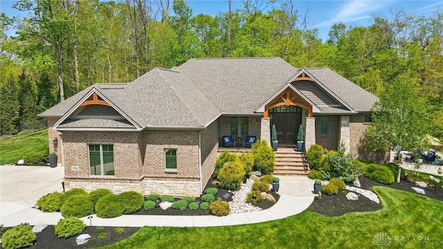 craftsman house featuring a front yard and stone siding