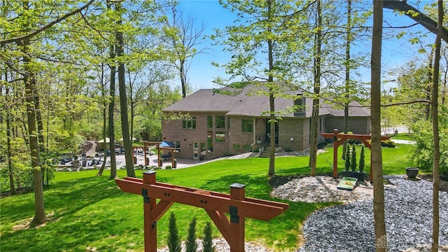 rear view of house with a lawn and brick siding