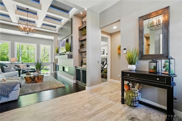 interior space featuring an inviting chandelier, beam ceiling, baseboards, wood finished floors, and coffered ceiling