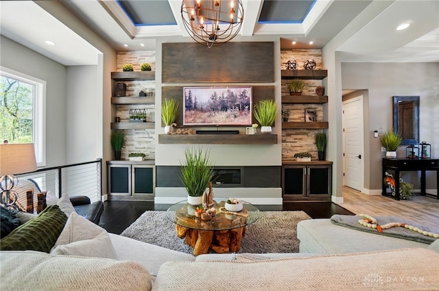 living area featuring an inviting chandelier, recessed lighting, a glass covered fireplace, and wood finished floors