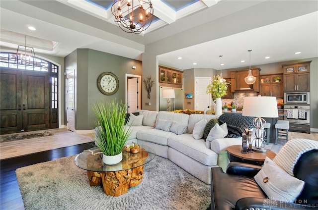 living area with recessed lighting, light wood-style flooring, baseboards, and a notable chandelier