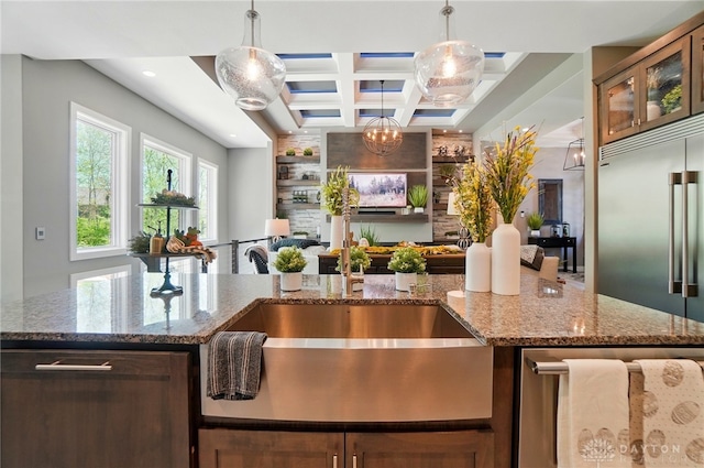 kitchen featuring hanging light fixtures, stone countertops, coffered ceiling, and open floor plan