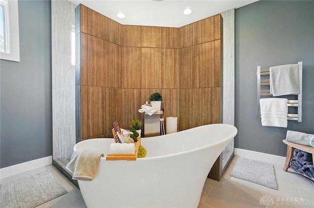 full bath with tile patterned flooring, baseboards, and a freestanding bath