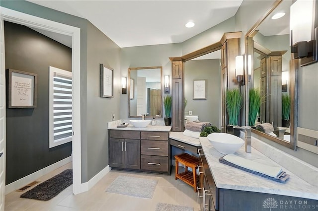 bathroom featuring vanity, tile patterned flooring, baseboards, and visible vents