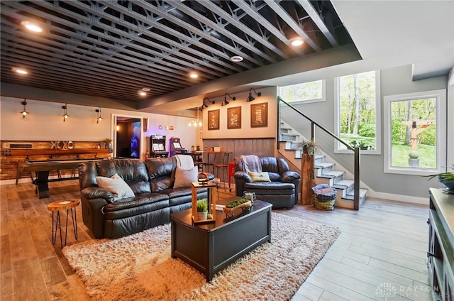 living room featuring wood-type flooring, stairs, and baseboards