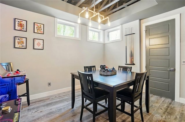dining space with baseboards and wood finished floors