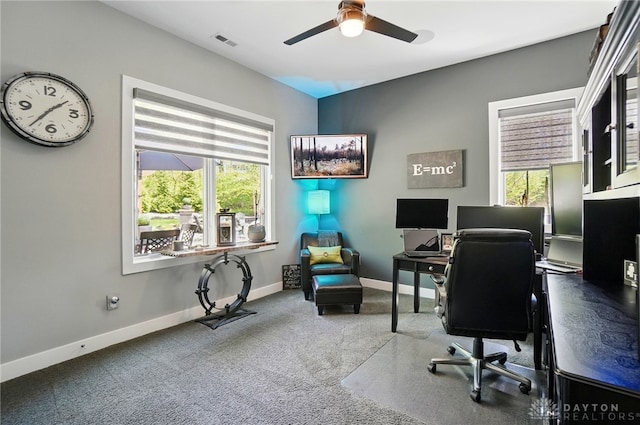 carpeted office space featuring visible vents, baseboards, and ceiling fan
