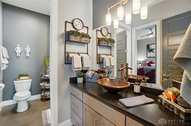 ensuite bathroom with toilet, baseboards, ensuite bathroom, and vanity