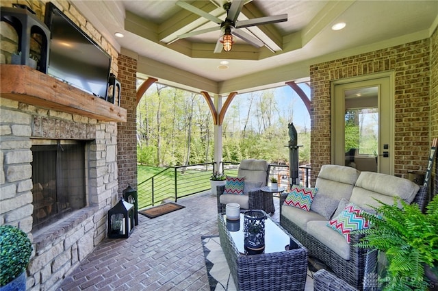 view of patio / terrace featuring an outdoor living space with a fireplace and ceiling fan