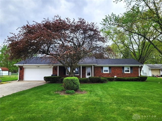 ranch-style house with brick siding, a front lawn, an attached garage, and driveway