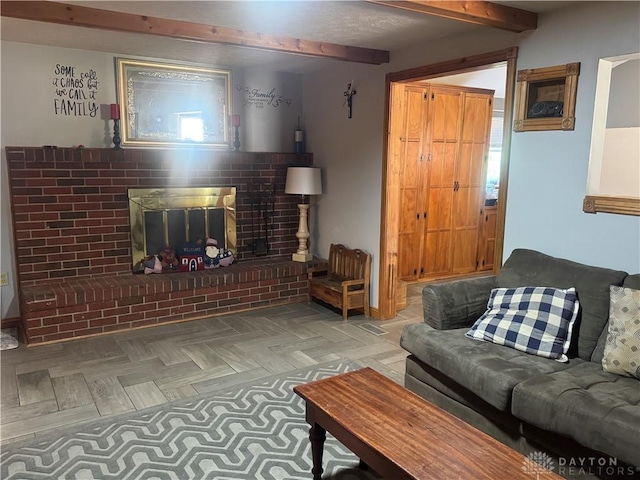 living area with a brick fireplace and beam ceiling