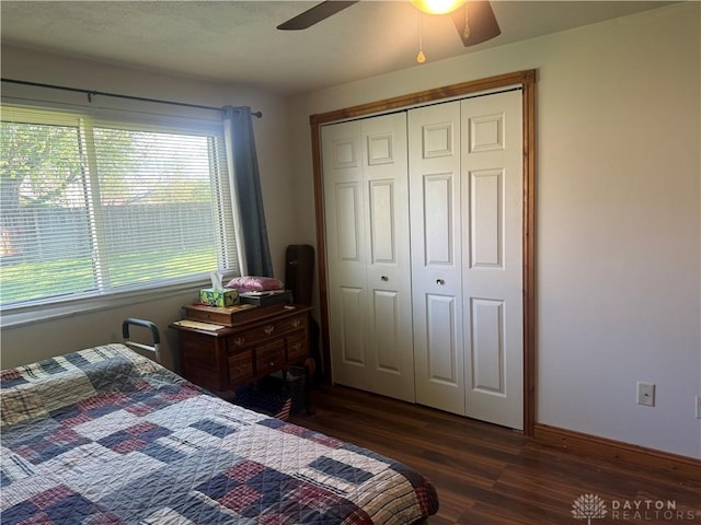 bedroom with a closet, baseboards, ceiling fan, and dark wood-style floors