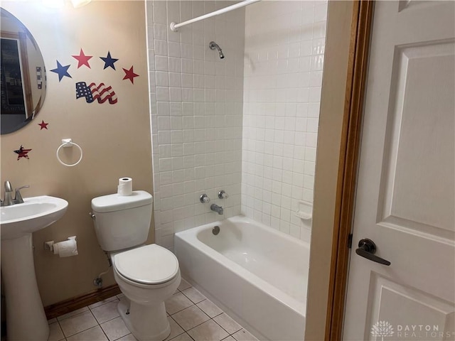 bathroom with toilet, shower / washtub combination, a sink, and tile patterned flooring
