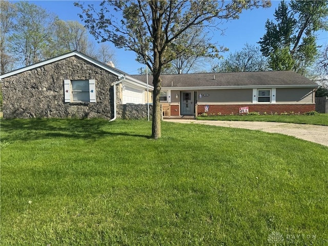 single story home featuring an attached garage and a front yard