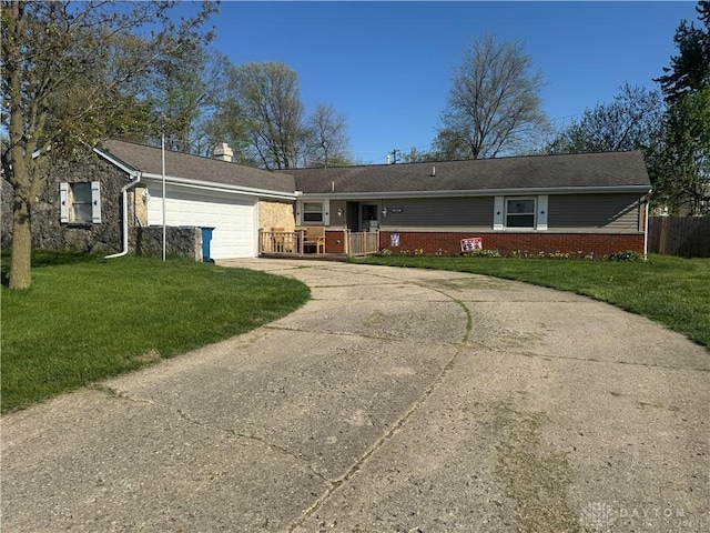 single story home with a front lawn, a chimney, brick siding, an attached garage, and driveway